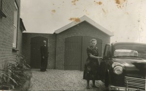 1957 Opa en oma Doomen - v d Vorstenbosch voor de garage naast hun huis in de Antoon v d Venstraat. Wat voor auto is dit?